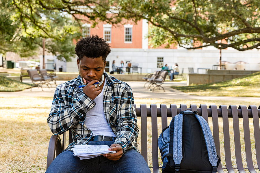 student studying on campus bench