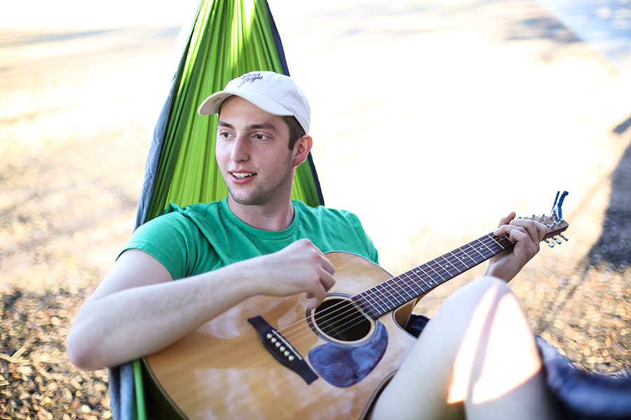 Student playing guitar in hammock 